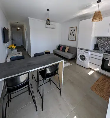 a kitchen and living room with a table and chairs at Apartamento da Praia in Sagres