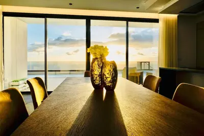 a vase with yellow flowers sitting on a wooden table at Vila Cales e Chadas by Your Madeira Rentals in Arco da Calheta