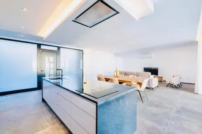 a kitchen and living room with a table and a couch at Vila Cales e Chadas by Your Madeira Rentals in Arco da Calheta