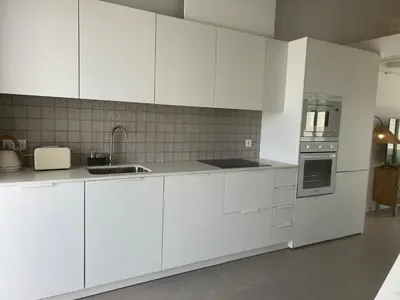 a white kitchen with white cabinets and appliances at Casa Ingrina in Carrapateira