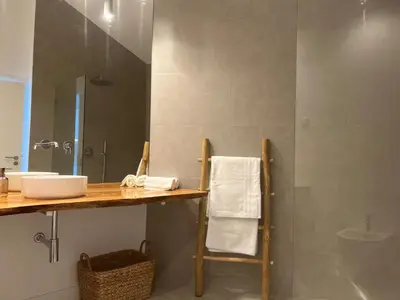 a bathroom with a sink and a shower with a mirror at Casa Ingrina in Carrapateira