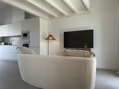 a living room with a white couch and a flat screen tv at Casa Ingrina in Carrapateira