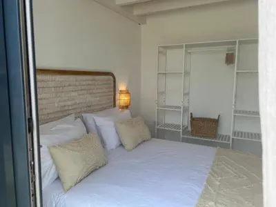 a bedroom with a bed with white sheets and pillows at Casa Ingrina in Carrapateira