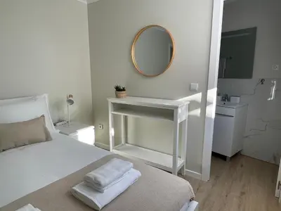 a white bedroom with a bed and a mirror at Brooklyn&Fennel House in Funchal