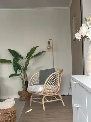 a rattan chair with a green pillow in a living room at Brooklyn&Fennel House in Funchal
