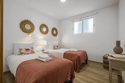 two beds in a room with white walls at Colinas by Homie in São Vicente