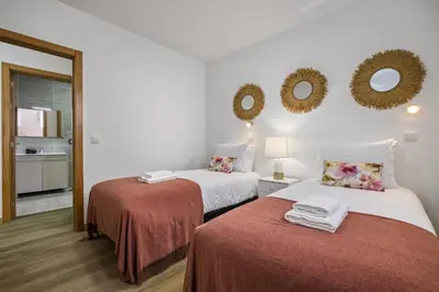 a room with two beds and mirrors on the wall at Colinas by Homie in São Vicente