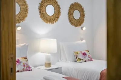 two beds in a room with mirrors on the wall at Colinas by Homie in São Vicente