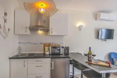 a kitchen with a counter with a sink and a microwave at Vila Luz Mar in Luz