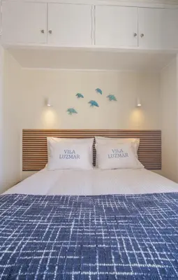 a bed with two pillows on top of it at Vila Luz Mar in Luz