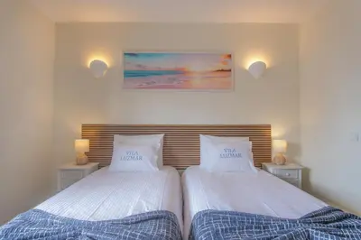 two beds sitting next to each other in a bedroom at Vila Luz Mar in Luz