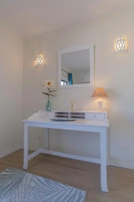 a white desk with a mirror and a lamp at Vila Luz Mar in Luz