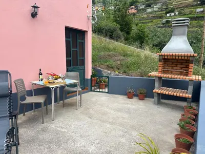 a patio with a table and a large vase at Casa Rosa in Ribeira Brava