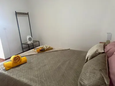 a bedroom with a bed with a yellow towel on it at Casa Rosa in Ribeira Brava