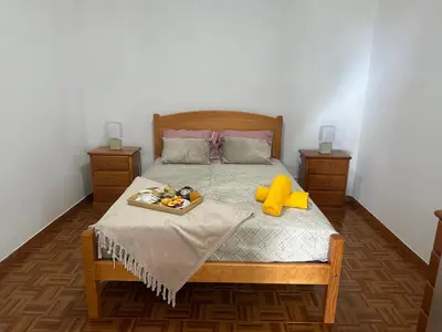 a bedroom with a bed with a tray of food on it at Casa Rosa in Ribeira Brava