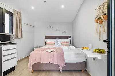 a bedroom with a bed with a pink blanket on it at Seaside Sunset by Homie in Paul do Mar