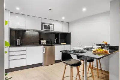 a kitchen with white cabinets and a table and chairs at Seaside Sunset by Homie in Paul do Mar