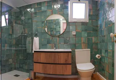 a bathroom with a toilet and a sink and a mirror at Renovated Traditional House w 3BR & Outdoor Space in Funchal