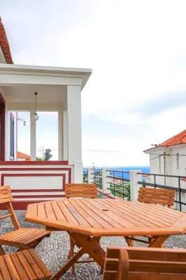 a wooden picnic table and chairs on a balcony at Renovated Traditional House w 3BR & Outdoor Space in Funchal