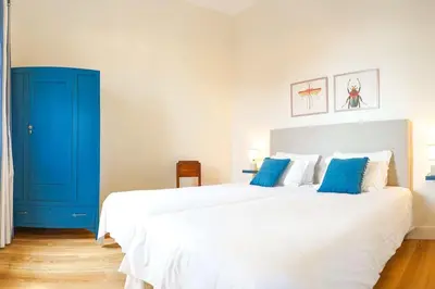 a bedroom with a large white bed and blue cabinet at Renovated Traditional House w 3BR & Outdoor Space in Funchal