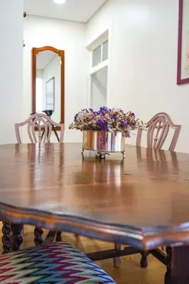 a wooden table with a vase of purple flowers on it at Renovated Traditional House w 3BR & Outdoor Space in Funchal