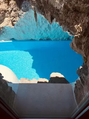 a view of a blue lake from inside a cave at Villas Calhau da Lapa 10 in Campanário
