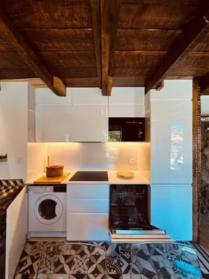 a kitchen with white cabinets and a washer and dryer at Villas Calhau da Lapa 10 in Campanário