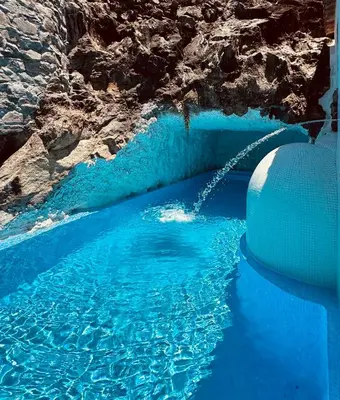 a pool of blue water with a water slide at Villas Calhau da Lapa 10 in Campanário