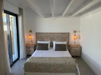 a bedroom with a bed and two lamps on two tables at Casa Zavial in Carrapateira