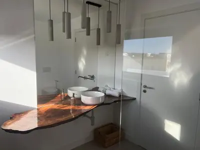 a bathroom with two sinks and a glass shower at Casa Zavial in Carrapateira