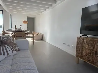 a living room with a couch and a flat screen tv at Casa Zavial in Carrapateira
