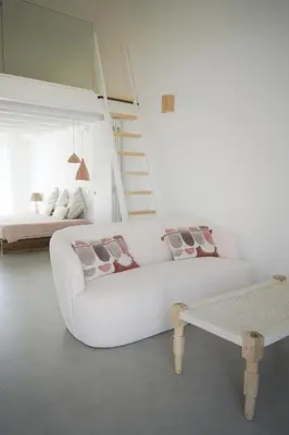 a white living room with a couch and a bed at Casa Barranco in Carrapateira