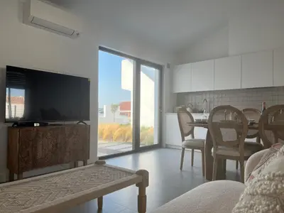 a living room with a television and a table with chairs at Casa Barranco in Carrapateira