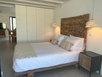 a bedroom with a bed with white sheets and pillows at Casa Barranco in Carrapateira