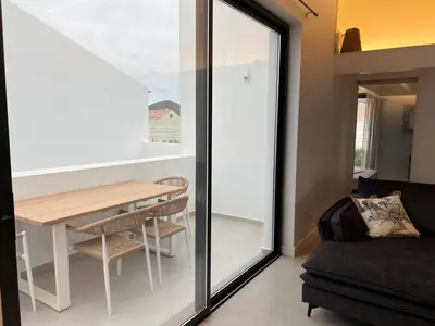 a living room with a table and a dining room at Casa Furnas in Carrapateira