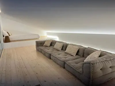 a living room with a couch and a bed at Casa Furnas in Carrapateira