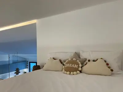 a teddy bear sitting on top of a bed at Casa Furnas in Carrapateira