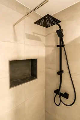 a shower with a black shower head in a bathroom at Casa Antonette, Lovely house with a pool in Calheta