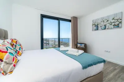 a bedroom with a large bed with a large window at Casa Antonette, Lovely house with a pool in Calheta