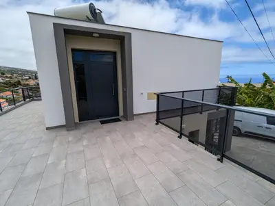 a balcony with a black door on a white building at Apartment Antonette in Calheta