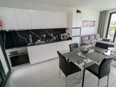 a kitchen and living room with a table and chairs at Apartment Antonette in Calheta