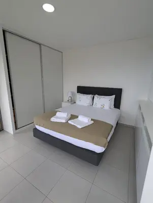 a white bedroom with a bed with towels on it at Apartment Antonette in Calheta