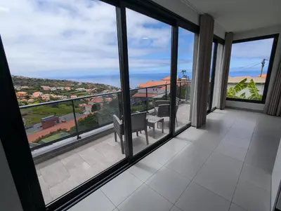 a room with large windows with a view of a city at Apartment Antonette in Calheta