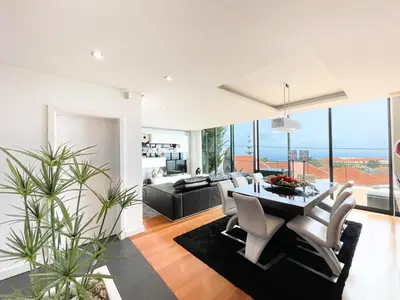 a dining room and living room with a table and chairs at Casa Refúgio dos Canhas in Ponta do Sol