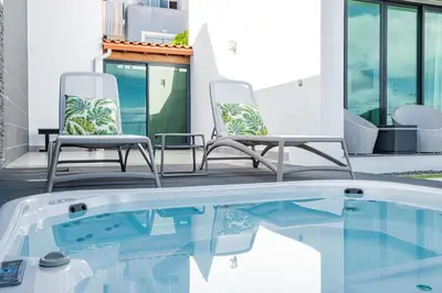 two chairs sitting next to a swimming pool at Casa Refúgio dos Canhas in Ponta do Sol