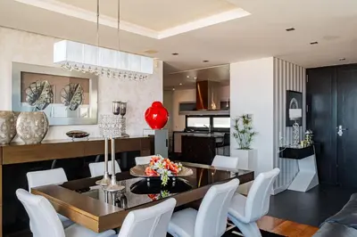 a dining room and kitchen with a table and white chairs at Casa Refúgio dos Canhas in Ponta do Sol