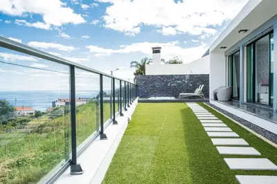 a balcony with grass and a view of the ocean at Casa Refúgio dos Canhas in Ponta do Sol