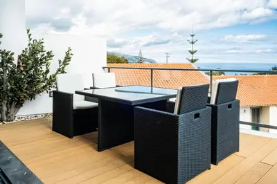 a patio with a table and chairs on a balcony at Casa Refúgio dos Canhas in Ponta do Sol