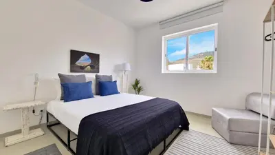 a bedroom with a bed and a window and a chair at Casa do Pico by Casas dos Lebre in Porto Santo