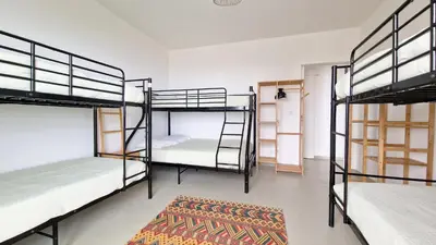 a room with three bunk beds and a rug at Casa do Pico by Casas dos Lebre in Porto Santo